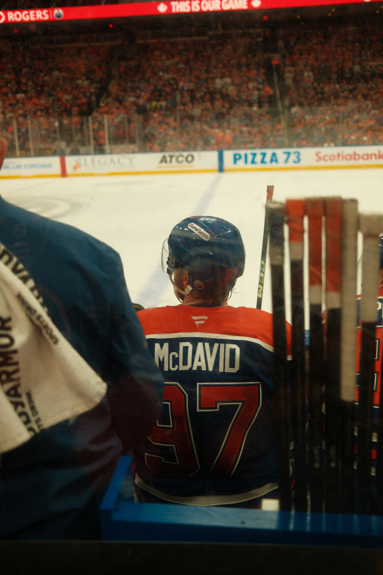 McDavid from behind at the bench through sticks and glass