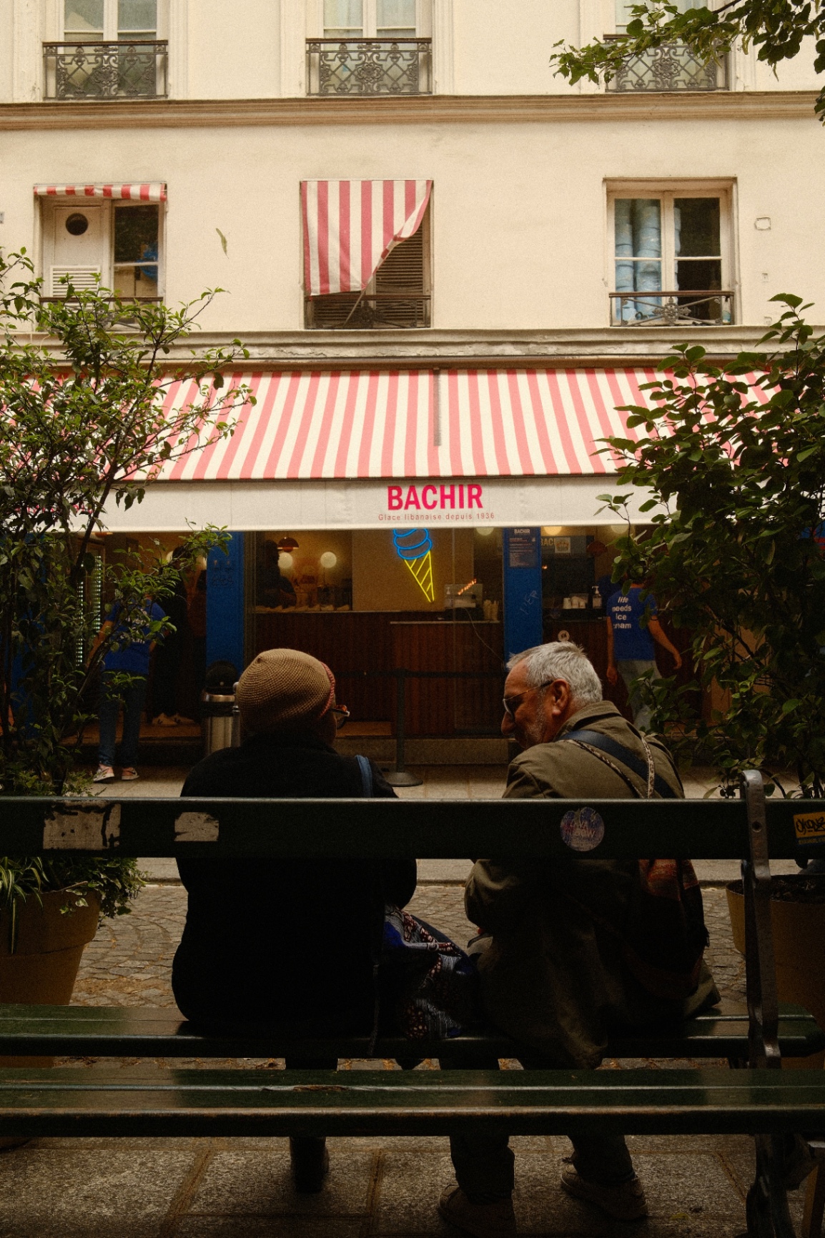 Two men on a bench outside a Paris storefront