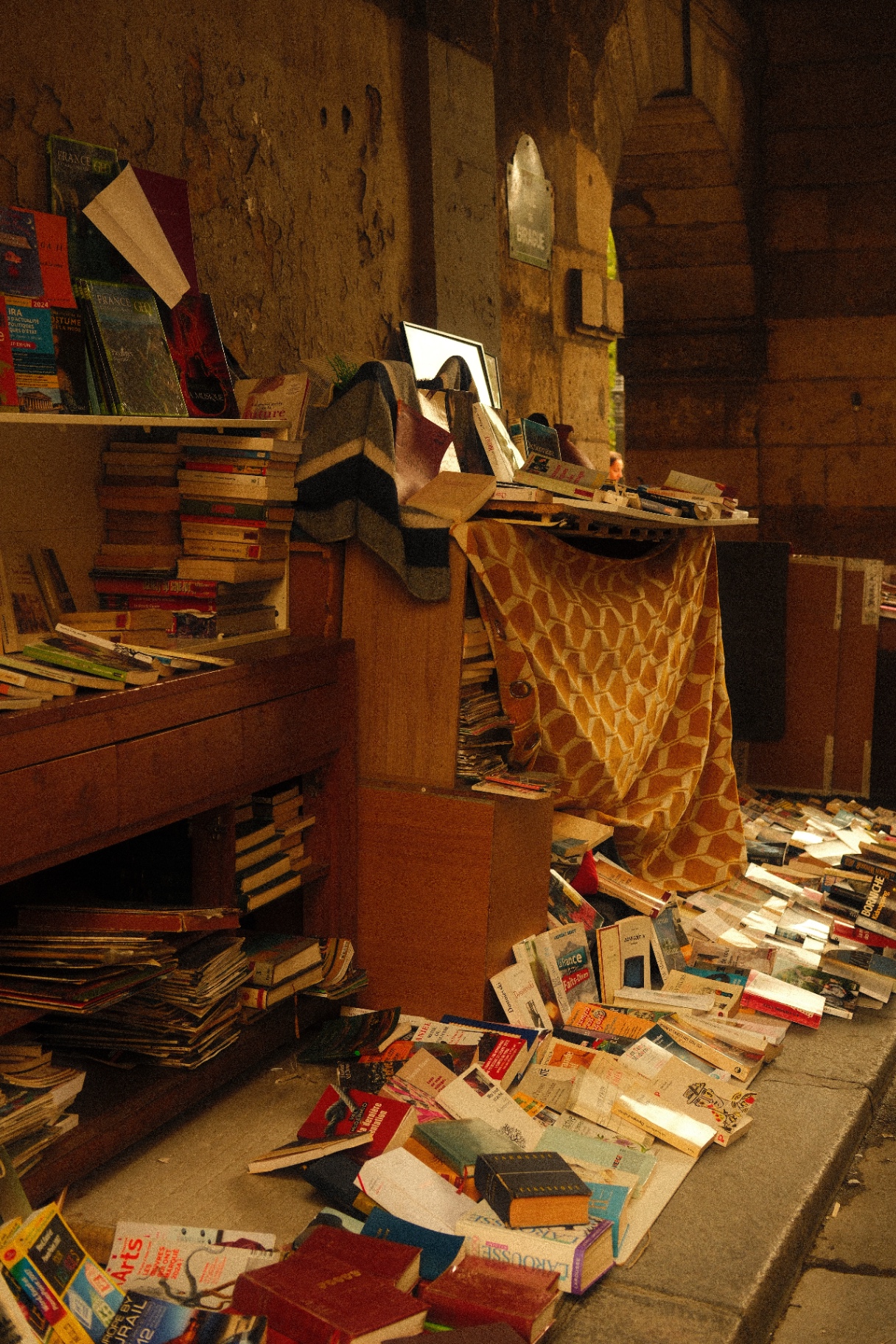 Spilled stacks of secondhand books and magazines outside a Paris bouquiniste