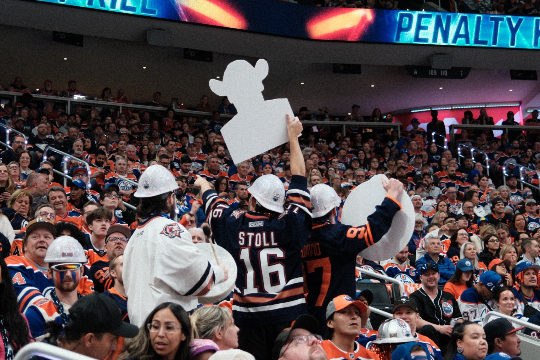 Fans in hard hats and jerseys during playoff atmosphere