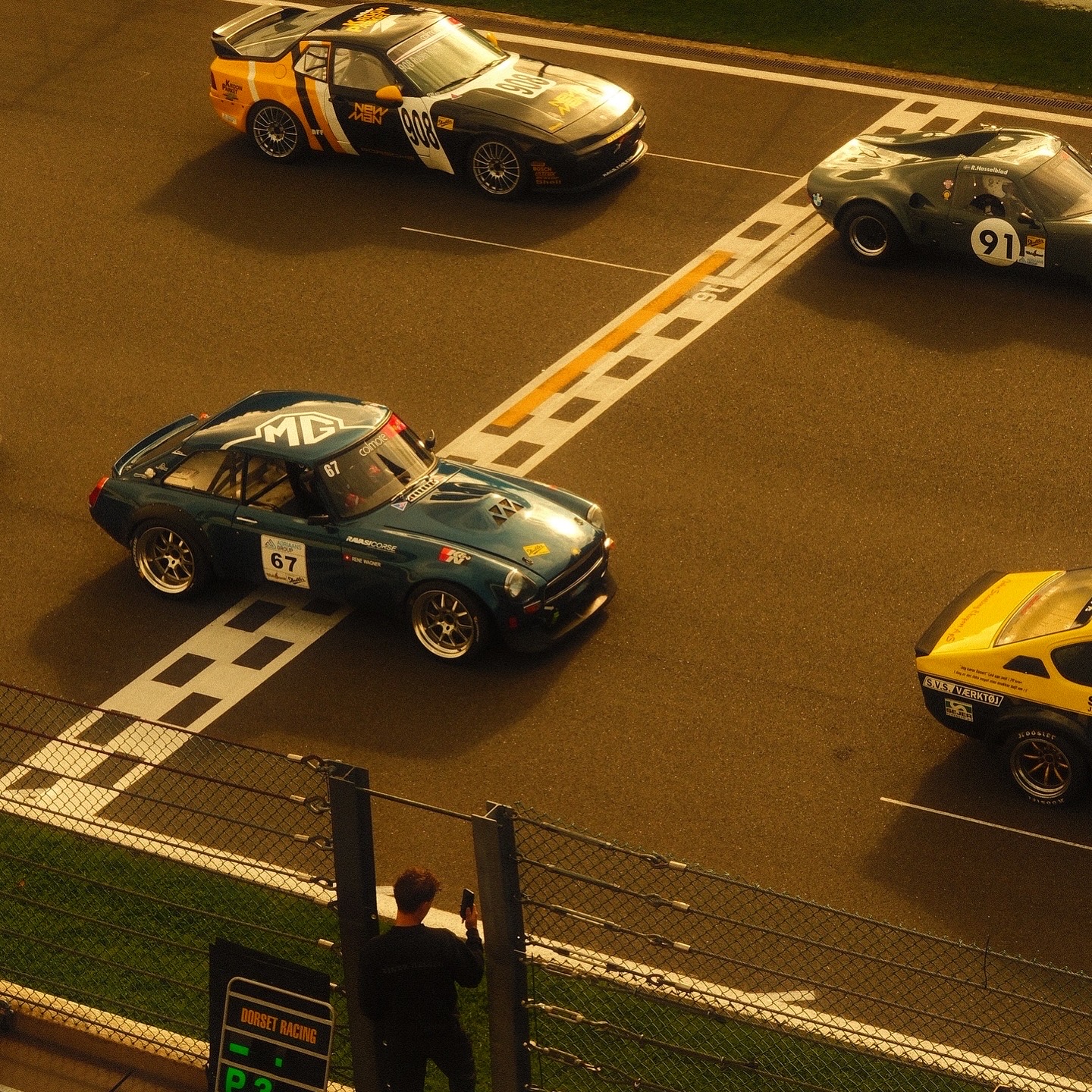 Vintage race cars on the grid seen from above in warm light