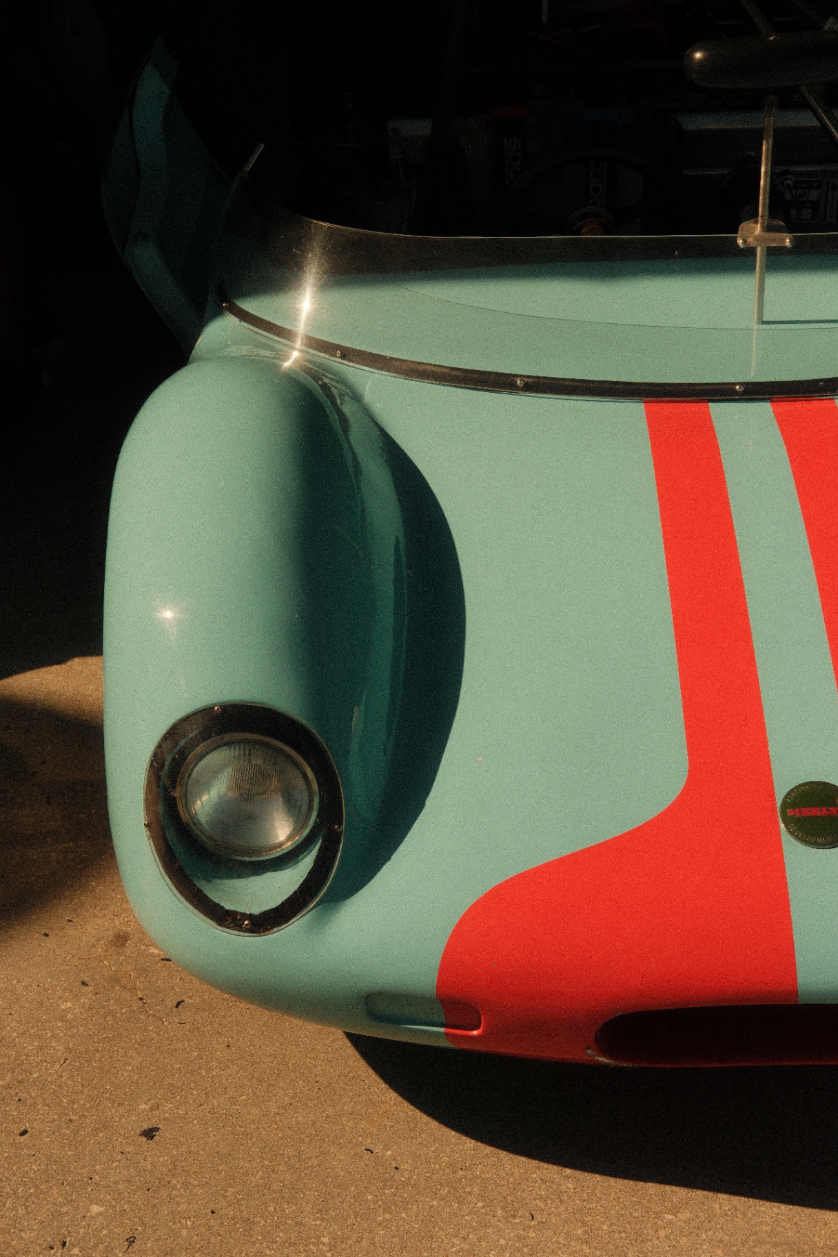 Detail of a mint and red Gulf-liveried sports car front fender