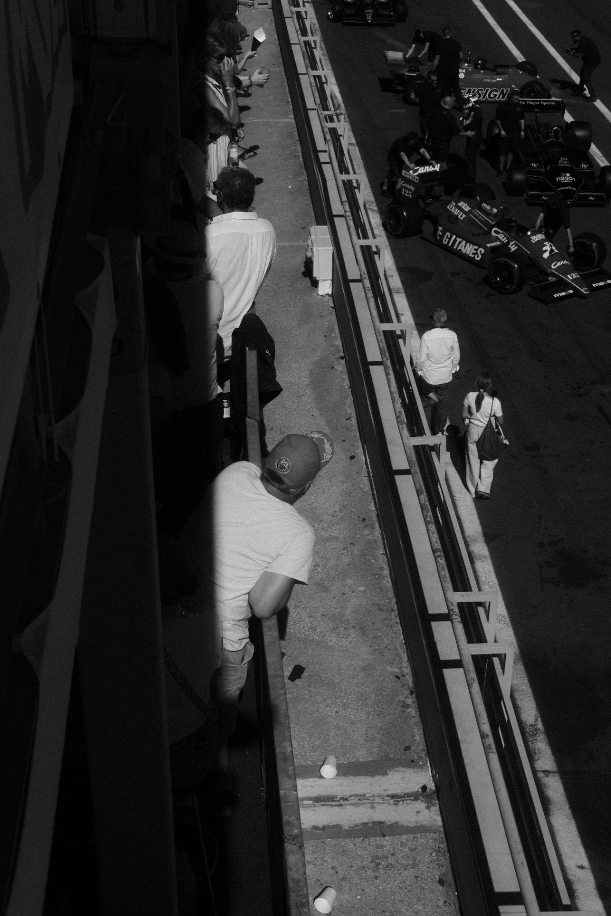 Pit lane from above in black and white, vintage F1 cars lined up