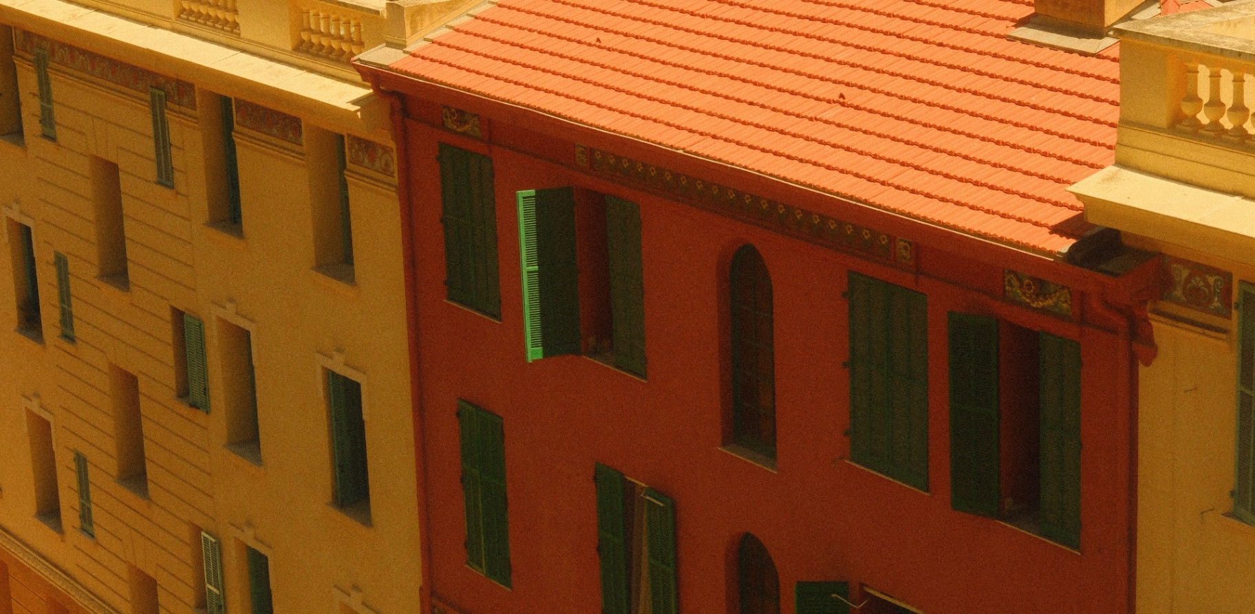 Ochre and red Monaco facades with green shutters and terracotta roof