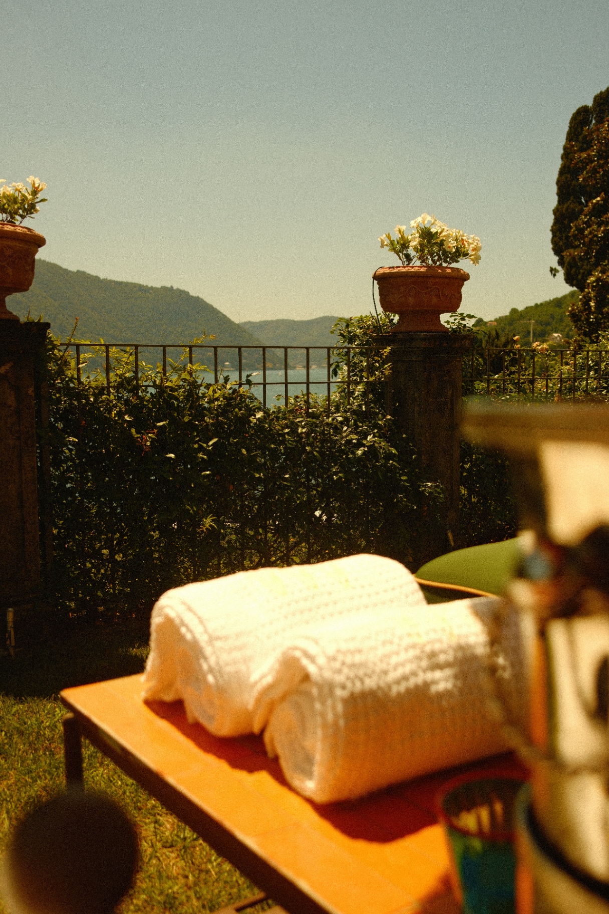 Sunlit table and lake view beyond the garden wall