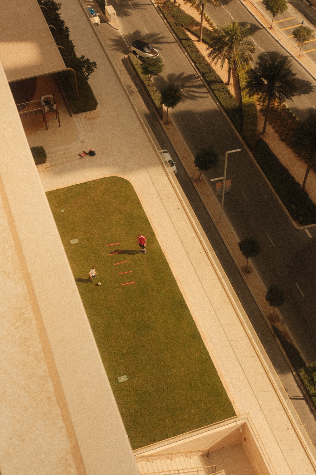 Grass field at a Dubai condominium seen from a balcony above