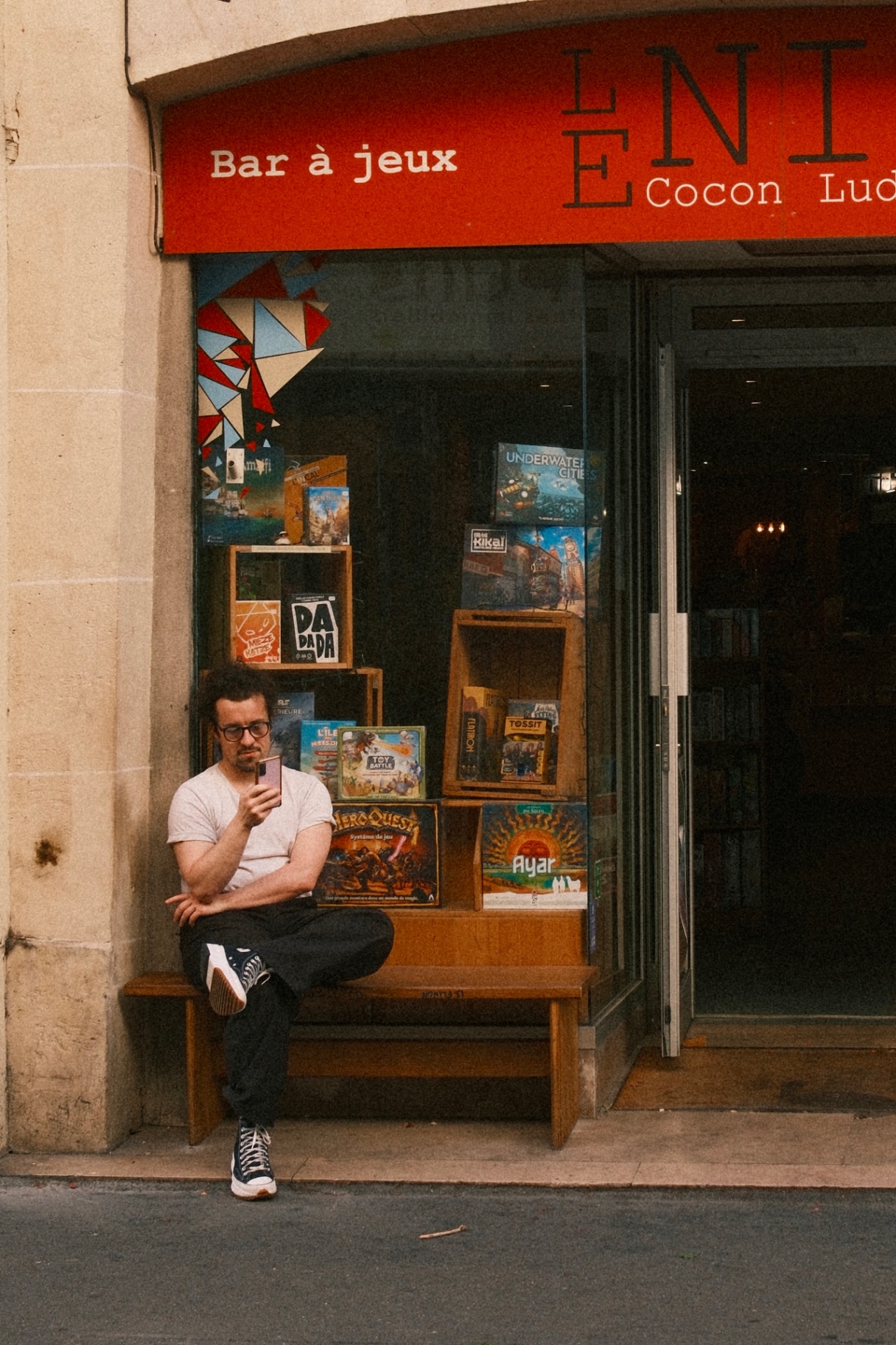 A man on a bench outside a shopfront